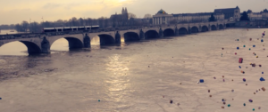 Vue sur le pont Wilson de Tours, chevauchant la Loire, une farandole de cadeaux tombe du ciel