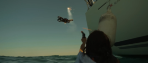 Femme dans l'océan tirant drone avec pistolet fusées de détresse