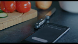 Téléphone qui sonne, sur un plan de travail, tomate, oignon, couteau, planche à découper